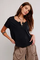 Remera henley de algodón liviano y jaspeado, de calce relajado, con mangas cortas, botonadura al cuello, aplicaciones de encaje y ruedo enrollado.