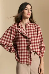 Camisa de algodón a cuadros con diseño de volados frontales, cuello alto y mangas largas con leve volumen.