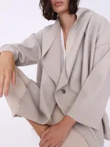 Saco espigado color beige, de corte holgado, con cuello solapa y doble botonadura.