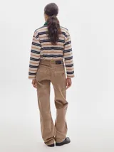 Pantalón de pana roja con corte holgado y tiro medio. Presenta una línea dorada a lo largo de la pierna.