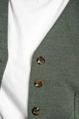 Chaleco verde militar con escote en V, corte al cuerpo y cierre frontal con botones marrones.