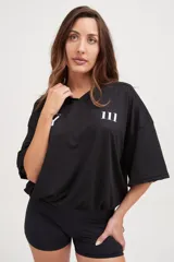 Camiseta negra de manga corta con cuello en V, corte holgado y cordón ajustable en la cintura.