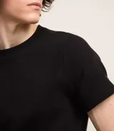 Remera muscle de hombre, color marrón claro, confeccionada en media malla, de cuello redondo y manga corta.