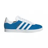 Championes adidas modelo Gazelle edición especial Real Madrid, confeccionados en gamuza azul con las icónicas tres tiras laterales en blanco. Presentan el nombre del club en letras doradas sobre el lateral y suela de goma blanca.
