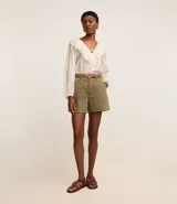 Short de mujer de sarga color beige claro, tiro alto, con pespunte contrastante en color blanco o crema. Presenta un corte regular y bolsillos delanteros y traseros.