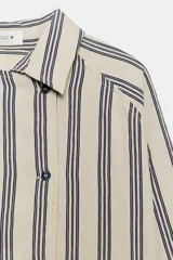 Camisa de corte oversize confeccionada en mezcla de viscosa, con estampado de rayas verticales. Presenta cuello solapa, cierre frontal con botones y mangas largas con puños amplios.