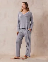 Conjunto de pijama marca René Rofé, compuesto por pantalón y remera a rayas grises y blancas. La remera es de escote en V, con bolsillo en el pecho y mangas largas. El pantalón tiene cintura elastizada y bolsillos laterales.