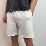 Short de algodón gris melange con cintura elástica y cordón de ajuste, de corte holgado y ruedo sin costura.