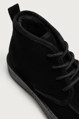 Bota de cordones de piel con acabado en serraje, color negro, con horma redonda y suela con volumen.