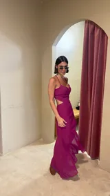 Vestido midi color uva con escote corazón, tirantes finos y aberturas laterales en la cintura. Presenta un diseño con frunces frontales y una falda con tajo lateral.