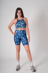 Calza biker deportiva de tiro alto con estampado floral en tonos azules y celestes. Confeccionada en tejido elástico de poliamida y elastano, presenta un diseño ajustado con logo de la marca estampado en la pierna.