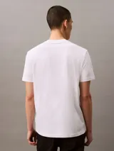Remera blanca de algodón con cuello redondo y logo "Calvin Klein Jeans" estampado en el pecho.