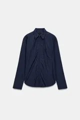 Camisa oversize de nylon color azul marino, con cuello solapa, manga larga, bolsillo de parche en el pecho y cierre frontal con cremallera.