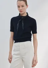 Jeans estilo wide leg de tiro alto en color crudo, con diseño de pernera ancha, trabillas para cinturón y costuras frontales marcadas.