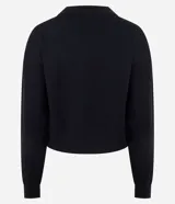 Suéter de punto color negro con escote en V estructurado, mangas largas y puños ajustados. Presenta un corte regular y diseño liso.