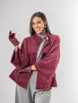 Chaqueta tipo capa de textura peluda en color bordó, con cuello mao y cierre frontal con botones grandes.