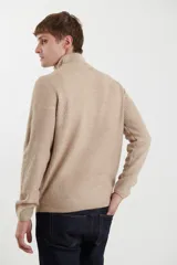 Sweater verde de punto inglés con cuello alto y cierre metálico frontal. Tiene mangas largas y terminaciones en punto canalé.