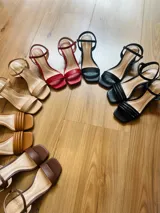 Sandalias de tacón cuadrado medio, con diseño de tiras finas y cierre de pulsera ajustable al tobillo. Confeccionadas en cuero sintético, presentan una punta cuadrada y un estilo minimalista y versátil.