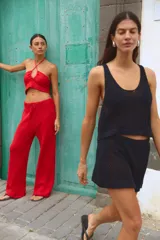 Top tejido de punto color rojo, con diseño halter y detalle de jareta ajustable en el centro del escote.
