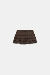 Shorts tipo pollera marrón de tiro medio, con cintura ajustable con cordones, diseño de múltiples volantes en capas y detalles de encaje a tono.