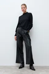 Blusa de color rojo con cuello alto y detalle de volados, mangas largas con puños elásticos en punto smock y textura sutil en la tela.