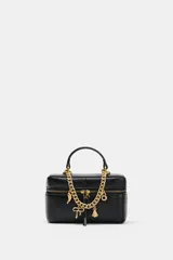 Bolso tipo vanity de estructura rígida y diseño acolchado con pespuntes. Cuenta con asa de mano superior y una cadena decorativa dorada con charms colgantes. Incluye cierre de doble cremallera y correa bandolera ajustable y extraíble.