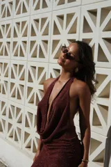 Vestido corto bordó con hilo brillante, escote halter pronunciado y detalle drapeado en el frente. Falda ajustada con fruncidos laterales y terminación con volados.