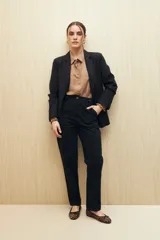 Pantalón negro de algodón, de tiro alto y corte recto, con bolsillos delanteros amplios con botones.