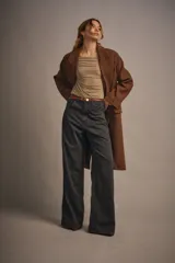 Pantalón de jean gris oscuro, de tiro alto y pierna ancha, con cinco bolsillos y costuras a contratono.