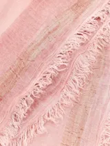 Chal rosado liviano con franja longitudinal de tonos más oscuros y bordes desflecados, confeccionado en tejido suave.