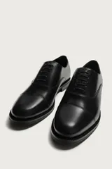 Zapato de vestir tipo oxford con puntera reforzada, confeccionado en piel de color marrón oscuro. Presenta cierre mediante cordones al tono, forro interior y plantilla de piel, y suela a contraste con tacón bajo.
