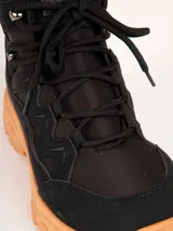 Bota de trekking color rosado con cordones al tono, cuello acolchado, ganchos metálicos para los cordones y suela dentada con plataforma gris y caramelo.