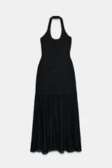 Vestido largo negro de cuello halter, espalda descubierta y escote redondo. Presenta un diseño de punto combinado en la parte superior y una falda larga de tejido fluido.