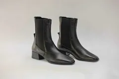 Botas de cuero color beige con elásticos laterales negros, taco cuadrado y punta cuadrada.