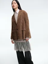 Blazer de pana color marrón con solapas clásicas, cierre frontal de dos botones y bolsillos laterales con solapa.