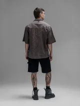 Camisa clásica de manga corta, color chocolate con efecto desgaste, confeccionada en algodón bordado (broderie) con diseño floral calado. Presenta cuello abierto y calce oversize.