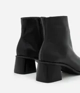 Bota de caña media Satinato confeccionada en cuero color marrón, con diseño de punta cuadrada y tacón bloque mediano.