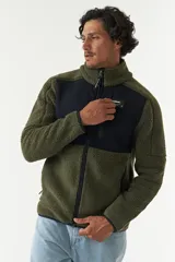 Campera de sherpa con paneles en contraste de color azul marino en el pecho y cuello alto. Cuenta con cierre frontal completo, bolsillos laterales y un bolsillo frontal con cierre, confeccionada en tejido de poliéster.