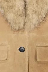 Blazer entallada de ante con cuello solapa y puños con aplicación de pelo sintético a contraste. Cuenta con cierre frontal de un botón y bolsillos delanteros con solapa.