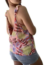 Blusa sin mangas con estampado de hojas en tonos rosa, amarillo, azul y negro. Tiene escote en V y tirantes con lazos.