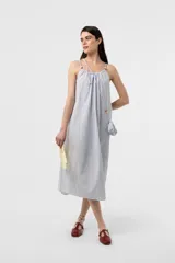 Vestido midi celeste de calce amplio y liviano, con escote fruncido regulable y breteles finos con detalles de cuentas. Presenta una silueta suelta e incluye una mini cartera desmontable al tono.