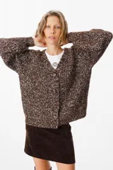 Saco tipo cardigan de tejido de punto con diseño jaspeado en tonos marrón chocolate y crudo. Presenta cuello en V, cierre frontal con botones grandes y mangas largas con hombros caídos.