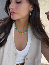 Collar corto con cuentas de cristal checo color turquesa, mostacillas color naranja y cuentas facetadas color amarillo. Se cierra con cadena de acero quirúrgico y ganchito para regular el largo.