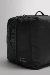 Mochila negra de tejido técnico con compartimento principal con cierre de cremallera y dos compartimentos internos con cierre de cremallera. Bolsillo frontal con cierre de cremallera, asa de mano, asa de hombro ajustable y extraíble, y dos asas de hombro acolchadas y ajustables con cinta con hebilla de liberación rápida.