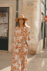 Blazer beige con estampado de unicornios alados y besos rojos.