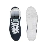 Championes Lacoste modelo Baseshot, de diseño urbano y perfil bajo. Confeccionados en gamuza color azul marino, presentan cordones blancos, suela de goma blanca y el logo del cocodrilo bordado en el lateral con la inscripción EST. 1933.