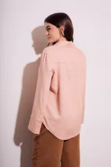 Camisa color salmón de corte oversize, confeccionada en lino y viscosa, con cuello clásico, cierre frontal con botones y mangas largas con puños anchos.