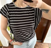 Remera de manga corta con diseño a rayas horizontales en color negro, blanco y gris, escote redondo y mangas con volados.