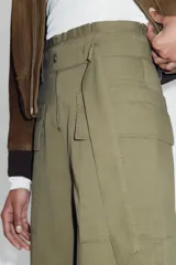 Pantalón de tiro alto con diseño paperbag, pernera ancha y cierre frontal con cremallera. Cuenta con bolsillos laterales de plastrón con solapa y cintura con trabillas.