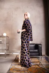 Pantalón de corte evasé confeccionado en tela calada con diseño de círculos de terciopelo. Presenta cintura elástica con cierre y un calce holgado y cómodo.